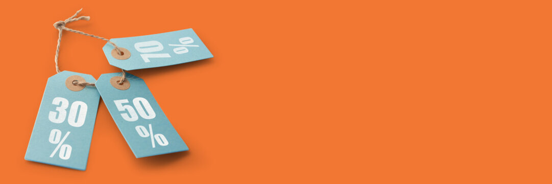 Three blue tags with discount signs on an orange background