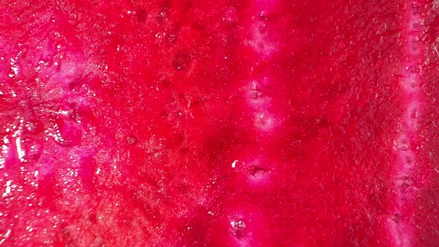 Captivating macro video showcases a half beetroot in stunning detail, revealing intricate textures, vibrant colors, and the mesmerizing patterns hidden within its layers. Beetroot background. 4K HDR
