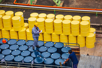 Male worker inspection record drum oil stock barrels yellow vertical or chemical for transportation truck male - obrazy, fototapety, plakaty