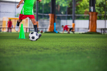 Soccer ball tactics children kick to control the ball on a grass field for the training