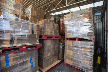 Folded cardboard boxes in the warehouse. Stack of flat industrial folding cardboard packing