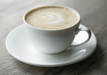 Cup of hot cappuccino coffee on table