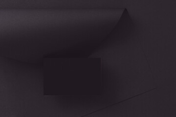 Black business card mockup on black paper background