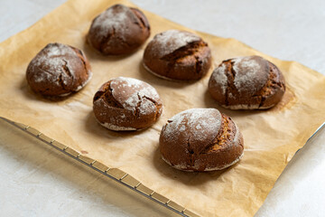 Warm rye buns on baking paper