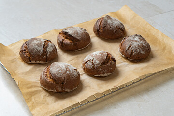 Warm rye buns on baking paper