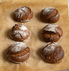 Warm rye buns on baking paper