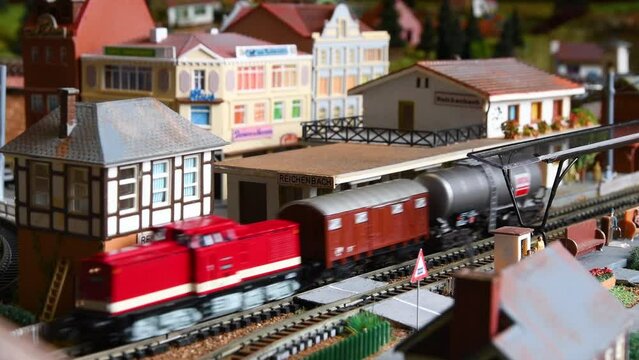 Freight model train passing through the station. Model railway.