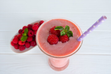 Raspberry smoothie red colorful fruit juice milkshake blend beverage healthy high protein the taste yummy In glass drink episode morning on white wood background from top view.