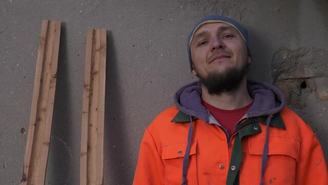Portrait of an adult Caucasian male in work clothes next to the didgeridoo halves. Australian Aboriginal wind instrument maker. Individual entrepreneurship. Small family business