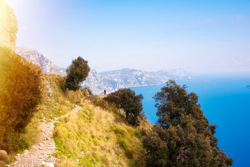 Person walking on scenic coastal trail on Amalfi coast in Italy