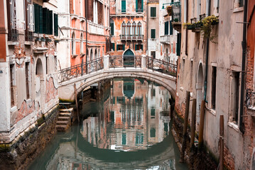 Fototapeta na wymiar Narrow canal with a bridge in Venice, Italy