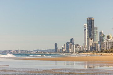 Golden sand of the Main Beach on the Gold Coast with the Surfers Paradise tourism destination city skyline in the distance, view from Southport down the beach