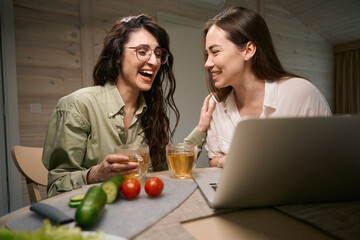 Young friends watching movie on computer and communicates