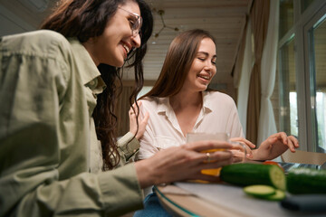 Smiling friends watching video on laptop and talking