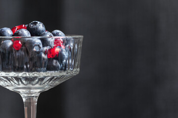 Fresh blueberries with pomegranate seeds in a glass bowl. Healthy snack. Organic food.  Dieting. Loosing weight.