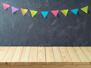 Empty wooden table over blackboard background with colorful banners.  Back to school concept for...