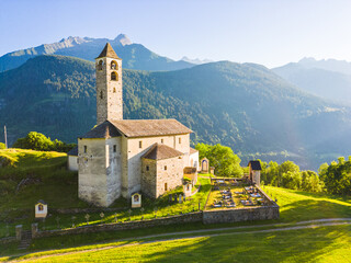 Aerial view of a church in Rossura in Switzerland during a sunset in a summer day, Rossura, Faido,...