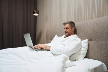 Man resting and working on computer in the hotel