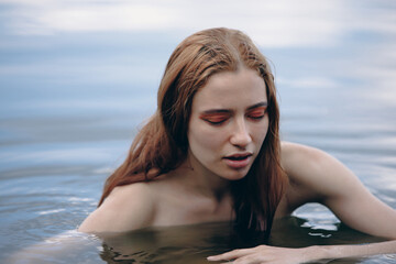 Portrait of naked woman swimming in a lake - 618823999