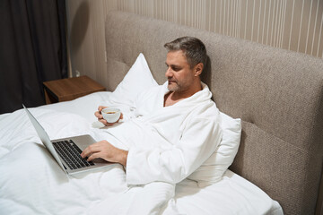 Adult male resting and watching movie on laptop