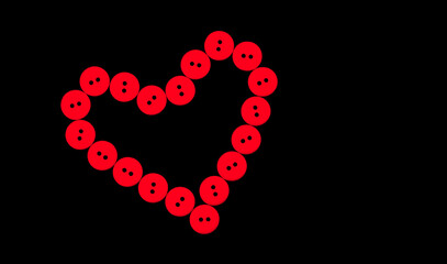 Shape of heart from red buttons on a black background. Symbol of love