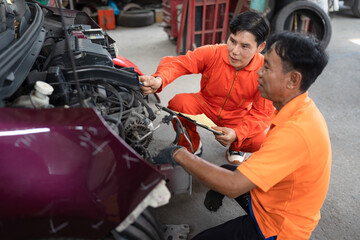 Fototapeta na wymiar Asia mechanic man checking and repair chain with machine at car service