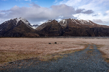 Scenic view along the Mount Cook Road alongside with snow capped Southern Alps basking in the late winter evening light. Best road trip route in New Zealand South Island with majestic Mount Cook. 