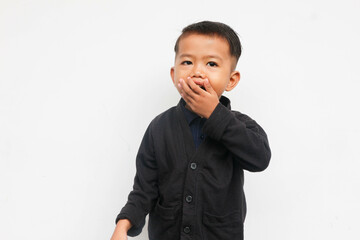A smiling toddler boy closing his mouth while looks at the camera with confidence, isolated on white background