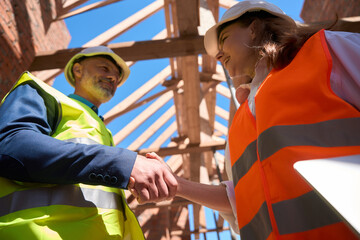 General forewoman shaking hand to contractor, making deal for roof covering