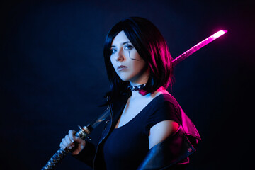 Portrait of a young woman with a bob hairstyle in a black leather jacket with a katana in her hands...
