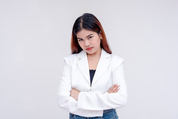 An irate and angry young woman arms crossed and glaring into the camera. Isolated on a white background. - obrazy, fototapety, plakaty