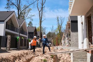 Foreman in business suit showing to female investor her future house