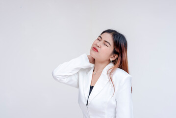 Obraz premium A pained young woman with tilted head holding her stiffed neck in pain. Isolated on a white background.
