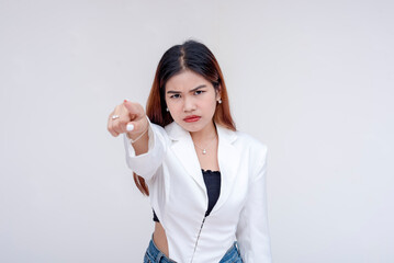 An irked and irritable young woman glaring and pointing at the camera. Isolated on a white background. - obrazy, fototapety, plakaty