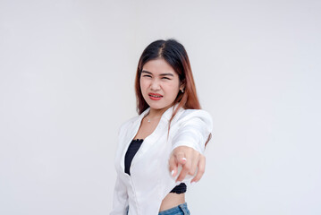 A disgusted young woman grimacing while pointing at the camera with her eyes narrowed. Isolated on...
