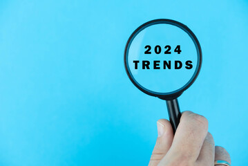 Focused on trend for next year 2024 concept. Words 2024 trends under magnifying glass. Card design. 