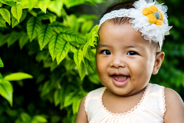 Cute little Asian infant sitting on garden.,happy 7 month baby girl