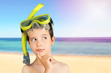 Pensive child with snorkel mask tuba and snorkel looks away at copyspace thinking at beach,funny...