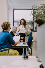 Fototapeta premium Lovely curly business girl listening to her senior colleague