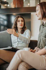 Girl with laptop making conversation in university hallway