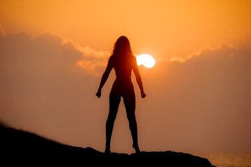 Silhouette of a Mentally and Physically Strong Woman on a Top at Sunrise