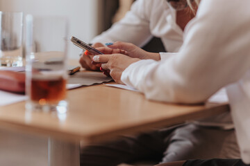 Businesswoman showing something on phone to her male partner, close up photo