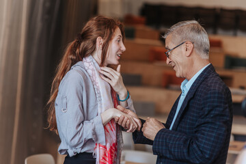 Mature businessman shaking his junior female employee, senior businessman greeting his employee....