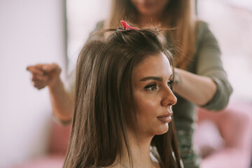 Naklejka premium Brunette girl making a hairstyle at the salon before wedding 