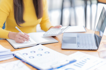 Attractive young office worker holding a  binder as she looks at the camera with a sweet friendly smile