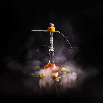 Kalyan. Citrus mix. Next to it is a leaf and a slice of orange and lemon. with smoke.