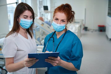 Chief physician discussing the patient's case status with medical nurse