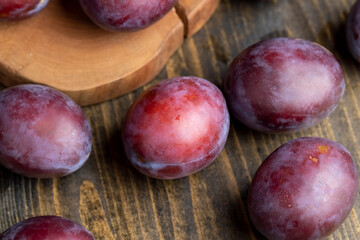 Ripe plums of dark color on the table