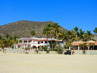 Vacation homes on the beach of the Gulf of California with the mountains in the background. Blue cloudless sky on a summer morning.