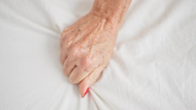Middle age woman having orgasm on bed at bedroom